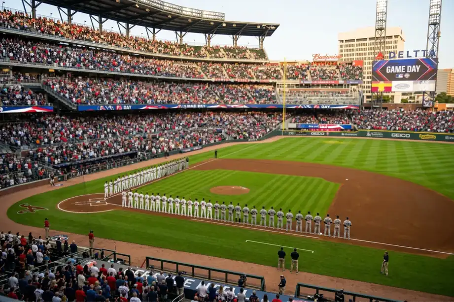 Two baseball teams lined up along the first-base and third-base lines before a game at a packed stadium